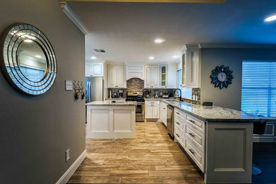Inspiration for a mid-sized modern l-shaped light wood floor and beige floor enclosed kitchen remodel in Houston with an undermount sink, raised-panel cabinets, white cabinets, granite countertops, multicolored backsplash, matchstick tile backsplash, stainless steel appliances and an island