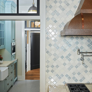 Design ideas for a mid-sized beach style single-wall kitchen pantry with a farmhouse sink, glass-front cabinets, beige cabinets, marble benchtops, white splashback, window splashback, stainless steel appliances, porcelain floors, no island and multi-coloured floor.