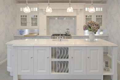 Photo of a large classic single-wall open plan kitchen in Essex with a built-in sink, shaker cabinets, white cabinets, quartz worktops, blue splashback, glass sheet splashback, stainless steel appliances, ceramic flooring and an island.