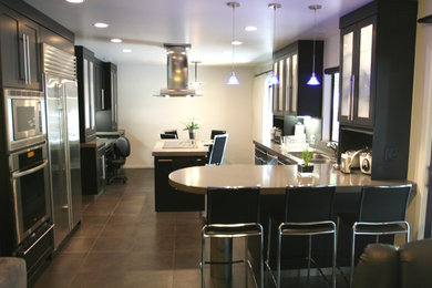 Open concept kitchen - large contemporary porcelain tile open concept kitchen idea in Los Angeles with an undermount sink, recessed-panel cabinets, black cabinets, quartz countertops, gray backsplash, stainless steel appliances and an island
