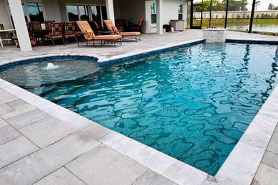 Ejemplo de piscina alargada tradicional renovada de tamaño medio a medida en patio trasero con adoquines de ladrillo