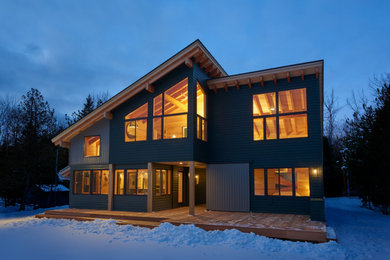 Imagen de fachada de casa verde rústica de dos plantas con revestimientos combinados, tejado de un solo tendido y tejado de metal