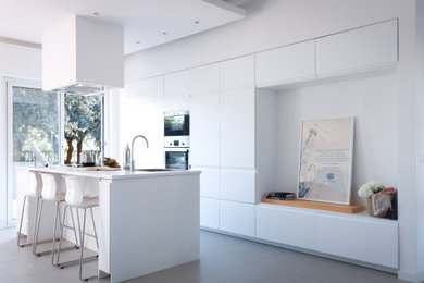 Immagine di una grande cucina contemporanea con lavello da incasso, ante lisce, ante bianche, top in laminato, elettrodomestici in acciaio inossidabile, pavimento in gres porcellanato, pavimento grigio, top bianco e soffitto ribassato
