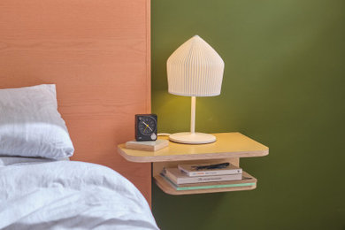 Modelo de dormitorio principal moderno de tamaño medio con paredes verdes, suelo de cemento, suelo gris y ladrillo