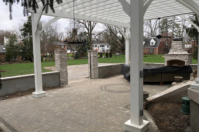 Mid-sized side yard brick patio photo in St Louis with a pergola