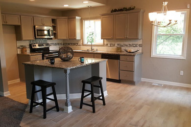 Open concept kitchen - small transitional l-shaped beige floor open concept kitchen idea in Kansas City with an undermount sink, recessed-panel cabinets, gray cabinets, granite countertops, white backsplash, subway tile backsplash, stainless steel appliances and an island