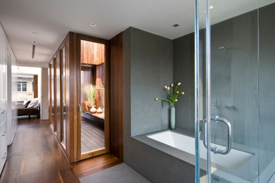 Photo of a modern bathroom in New York with an undermount tub and gray tile.