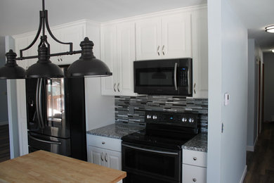 Example of a mid-sized transitional u-shaped dark wood floor and brown floor kitchen design in Other with an undermount sink, raised-panel cabinets, white cabinets, granite countertops, multicolored backsplash, matchstick tile backsplash, stainless steel appliances and an island