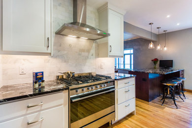 Mid-sized transitional galley light wood floor eat-in kitchen photo in Denver with an undermount sink, shaker cabinets, white cabinets, granite countertops, gray backsplash, marble backsplash, stainless steel appliances, a peninsula and black countertops