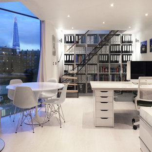 Diseño de estudio actual, pequeño, con paredes blancas, suelo de madera clara, estufa de leña y escritorio independiente