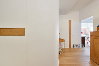 Imagen de recibidores y pasillos eclécticos de tamaño medio con paredes blancas, suelo de madera en tonos medios, suelo marrón, madera y iluminación