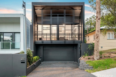 Inspiration for a small modern two-storey black house exterior in Brisbane with concrete fiberboard siding, a flat roof and a metal roof.