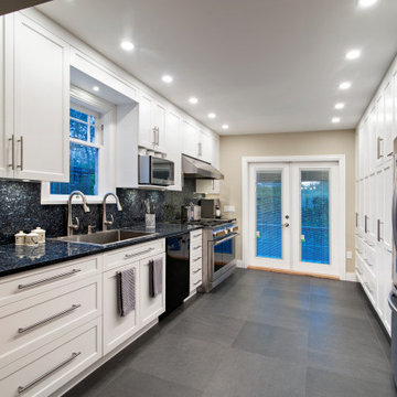 Functional & Stylish White Kitchen with Dark Countertops and Backsplash