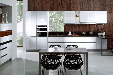 Large modern l-shaped eat-in kitchen in Los Angeles with a double-bowl sink, flat-panel cabinets, white cabinets, quartzite benchtops, stainless steel appliances, porcelain floors, a peninsula and white floor.