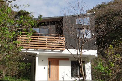 Foto de fachada de casa negra minimalista de tamaño medio de dos plantas con revestimiento de madera, tejado de un solo tendido y tejado de metal
