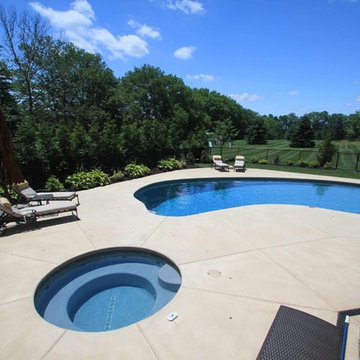 Kidney shaped in-ground salt water pool with outdoor kitchen