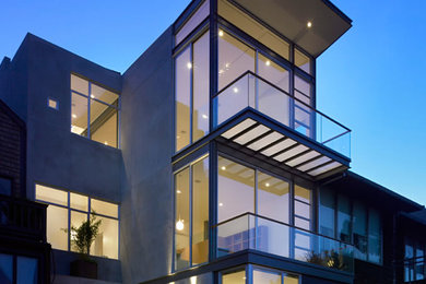 Mid-sized modern three-storey concrete grey exterior in Orange County with a flat roof.
