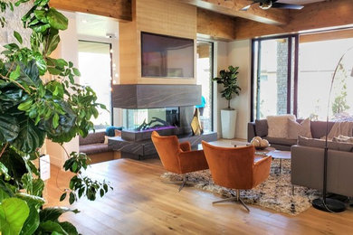 Inspiration for a modern medium tone wood floor family room remodel in Boise with white walls, a two-sided fireplace and a tile fireplace