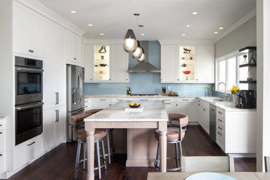 Example of a large transitional u-shaped dark wood floor and brown floor eat-in kitchen design in Raleigh with a double-bowl sink, shaker cabinets, white cabinets, quartzite countertops, blue backsplash, glass tile backsplash, stainless steel appliances, an island and white countertops