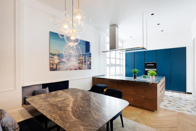 Idées déco pour une cuisine américaine contemporaine avec un placard à porte plane, des portes de placard bleues, îlot et un sol multicolore.