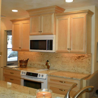 Kitchen pantry ideas - Example of a galley kitchen pantry design in Cedar Rapids with recessed-panel cabinets, light wood cabinets, granite countertops, beige backsplash, white appliances and no island