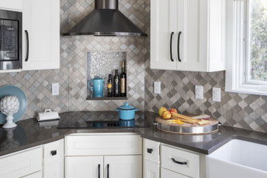 Inspiration for a mid-sized transitional l-shaped eat-in kitchen in Milwaukee with a farmhouse sink, recessed-panel cabinets, light wood cabinets, granite benchtops, multi-coloured splashback, glass tile splashback, stainless steel appliances, vinyl floors, with island, grey floor and white benchtop.