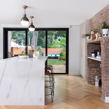 Eclectic Brownstone Kitchen with Exposed Brick and Marble Waterfall Island - Bro