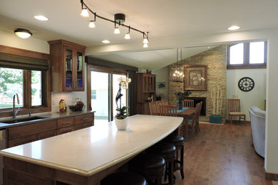 Inspiration for a transitional brown floor and medium tone wood floor dining room remodel in Milwaukee with yellow walls, a standard fireplace and a stone fireplace