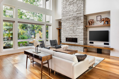 Inspiration for a large contemporary formal and open concept medium tone wood floor and brown floor living room remodel in San Francisco with white walls, a ribbon fireplace, a stone fireplace and a wall-mounted tv