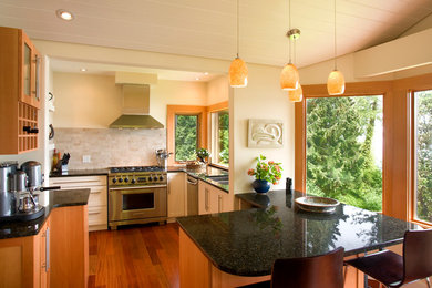 Transitional medium tone wood floor eat-in kitchen photo in Vancouver with granite countertops, beige backsplash, stainless steel appliances and a peninsula