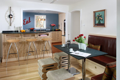 Photo of a small contemporary u-shaped eat-in kitchen in Other with an undermount sink, flat-panel cabinets, light wood cabinets, blue splashback, stainless steel appliances, light hardwood floors, a peninsula and beige floor.