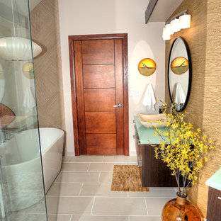 Esempio di una stanza da bagno padronale moderna di medie dimensioni con ante lisce, ante marroni, vasca freestanding, doccia ad angolo, WC monopezzo, piastrelle beige, piastrelle in gres porcellanato, pareti marroni, pavimento con piastrelle di ciottoli, lavabo a bacinella, top in vetro, pavimento beige, porta doccia a battente e top verde