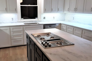 Eat-in kitchen - mid-sized traditional l-shaped light wood floor and brown floor eat-in kitchen idea in Charlotte with brown cabinets, marble countertops, white backsplash, ceramic backsplash, stainless steel appliances, an island and white countertops