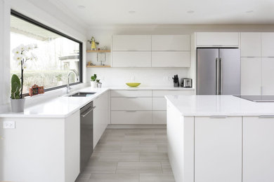 Eat-in kitchen - modern l-shaped porcelain tile and beige floor eat-in kitchen idea in Vancouver with an undermount sink, flat-panel cabinets, white cabinets, quartz countertops, white backsplash, quartz backsplash, stainless steel appliances, an island and white countertops