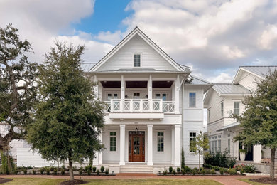 Beach style white three-story exterior home photo in Other with a metal roof and a gray roof