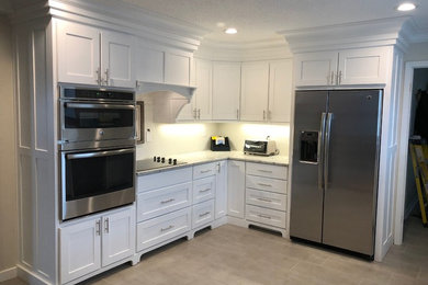 Example of a mid-sized transitional u-shaped porcelain tile and gray floor eat-in kitchen design in Other with shaker cabinets, white cabinets, granite countertops, stainless steel appliances, no island, white countertops and a double-bowl sink