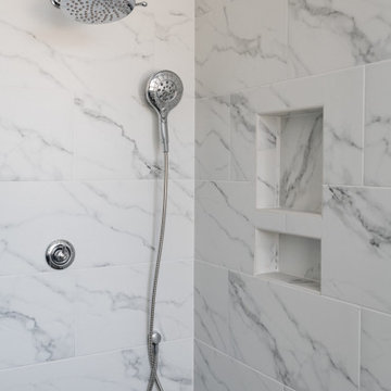 Clean White Bathroom with Pop of Blue cabinet and Gold pulls