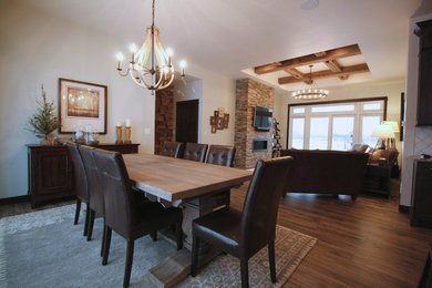 Example of a large transitional medium tone wood floor and brown floor great room design in Other with a standard fireplace, a stone fireplace and white walls