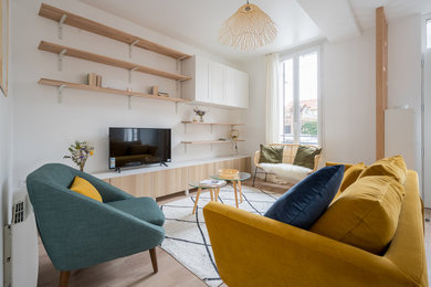 Example of a large danish open concept light wood floor living room design in Paris with white walls, no fireplace and a tv stand