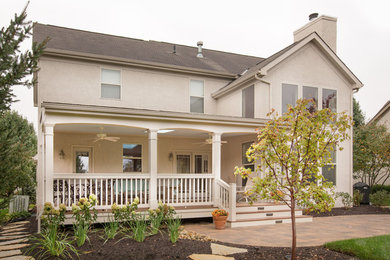 Inspiration for a mid-sized timeless brick back porch remodel in Columbus with a roof extension