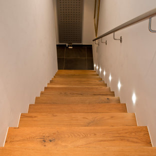 Gerade, Mittelgroße Urige Holztreppe mit Holz-Setzstufen, Stahlgeländer und Ziegelwänden in München