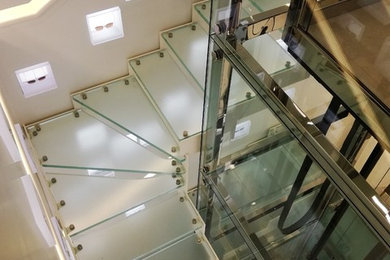 Expansive contemporary glass l-shaped staircase in Paris with open risers.
