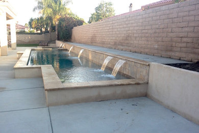 Example of a large classic backyard concrete paver pool fountain design in Other