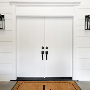 Flat panel exterior double doors before — builder-grade door upgrade with Luxe A