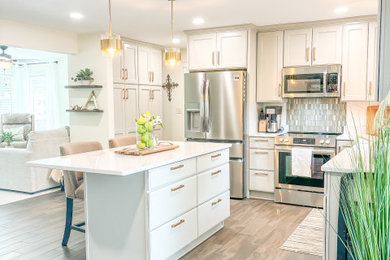 Eat-in kitchen - small contemporary l-shaped laminate floor and beige floor eat-in kitchen idea in Chicago with an undermount sink, shaker cabinets, beige cabinets, quartz countertops, beige backsplash, glass tile backsplash, stainless steel appliances, an island and white countertops