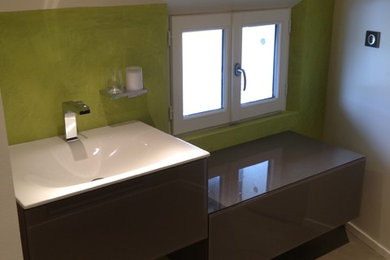 This is an example of a small modern bathroom in Bordeaux with an integrated sink, open cabinets, concrete benchtops, a wall-mount toilet, green tile, green walls, concrete floors and with a sauna.