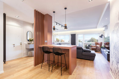 Esempio di un soggiorno design di medie dimensioni e aperto con angolo bar, pareti marroni e pavimento in laminato