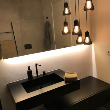 Dark bathroom vanity with black basin and pendant lights