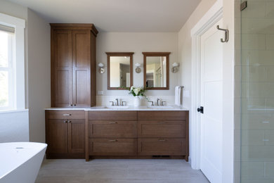 Freestanding bathtub - mid-sized transitional master white tile double-sink, porcelain tile and beige floor freestanding bathtub idea in Seattle with shaker cabinets, dark wood cabinets, a built-in vanity, white walls, a hinged shower door, white countertops, an integrated sink and quartz countertops