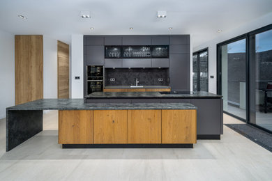 Aménagement d'une grande cuisine moderne avec un plan de travail en granite.